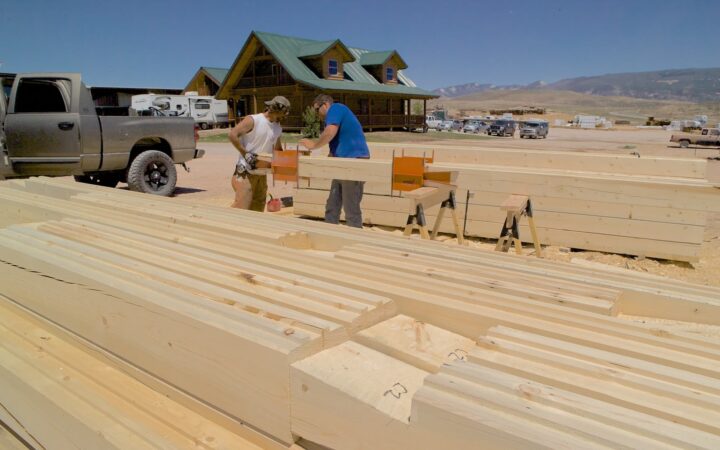 Satterwhite Log Homes carpenters saw logs at a mill.